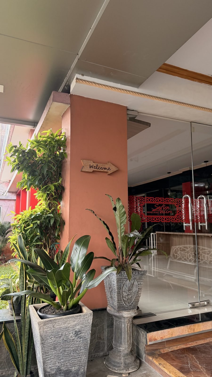 Pintu masuk yang asri dengan tanaman hijau